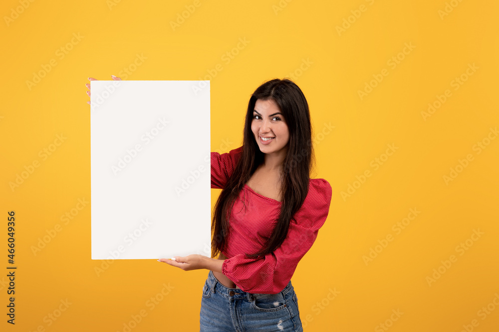 Place for your ad. Happy armenian woman holding blank placard with copy space for advertisement, text or design Place for your ad. Happy armenian woman holding blank placard with copy space for advertisement, text or design