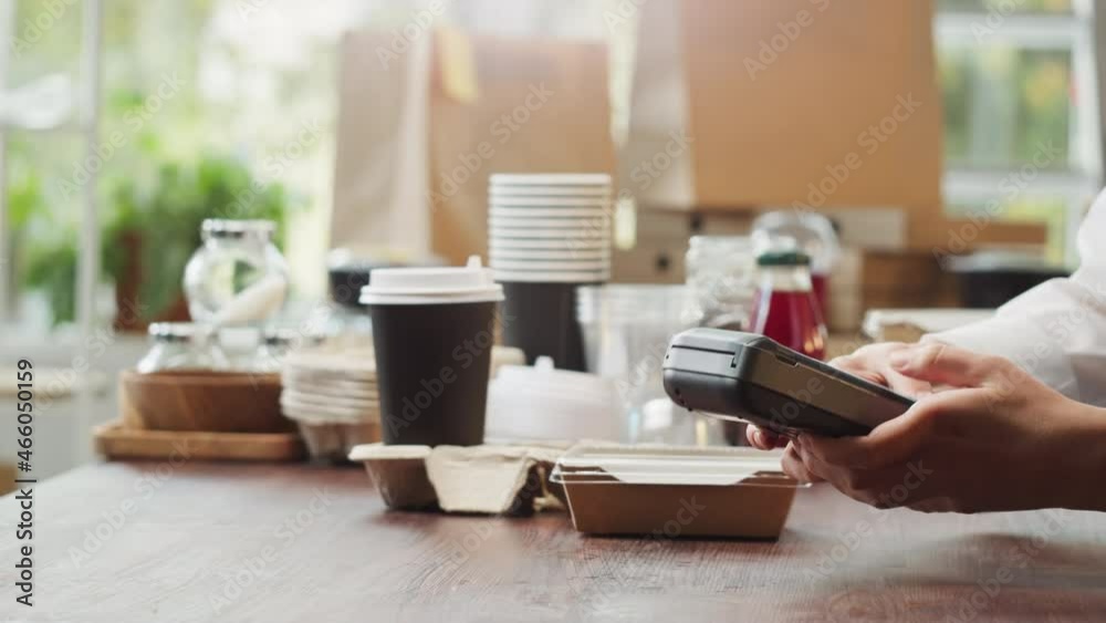 Paying with smartphone in cafe. Buying cooked food in lunch box and hot drink in paper cup. Take away container with fresh meal. Healthy eating habits. Contactless food shopping. Paying with smartphone in cafe. Buying cooked food in lunch box and hot drink in paper cup. Take away container with fresh meal. Healthy eating habits. Contactless food shopping.