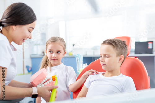 pediatric dentist shows young children how to brush their teeth properly. Children - a boy and a girl in doctor's office. concept is health of children's teeth.