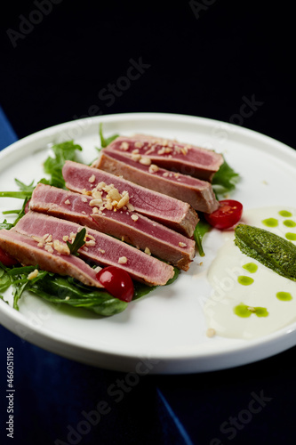 Slices of tuna ahi with fresh vegetable salad on a plate. 