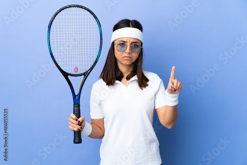 Young woman tennis player over isolated background counting one with serious expression