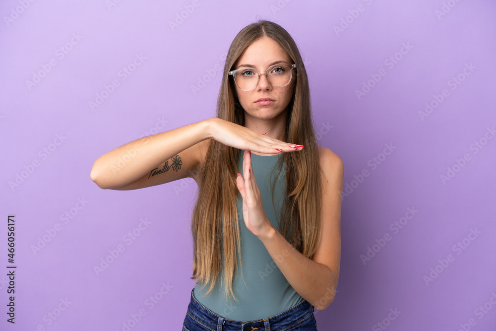Young Lithuanian woman isolated on purple background making time out gesture Young Lithuanian woman isolated on purple background making time out gesture