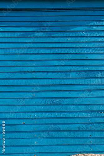 Background from horizontal planks in bright blue. Ultramarine wooden fence.