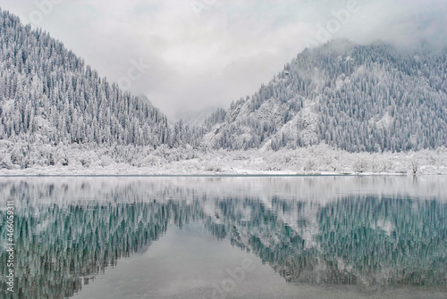 Mountain lake in winter. Snow-covered mountains are reflected in the water