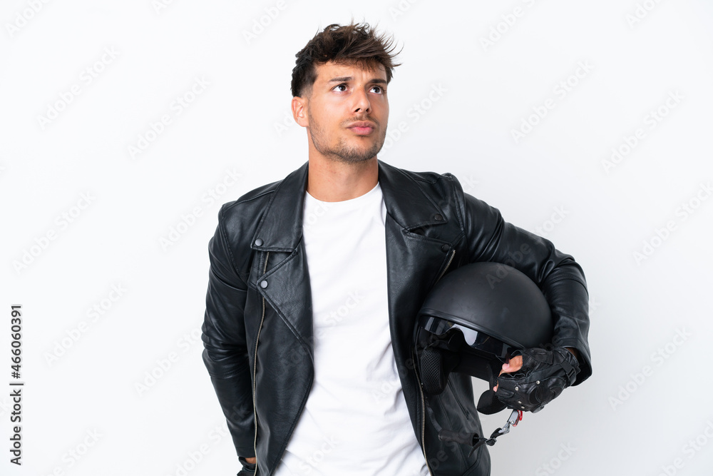 Young caucasian man with a motorcycle helmet isolated on white background and looking up Young caucasian man with a motorcycle helmet isolated on white background and looking up