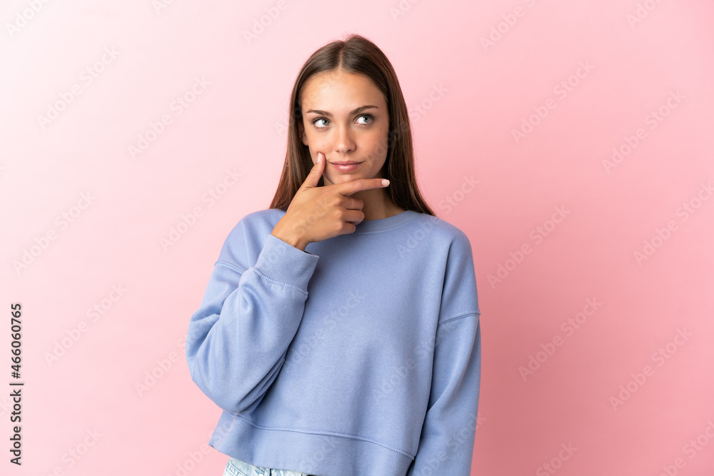 Young woman over isolated pink background thinking an idea while looking up