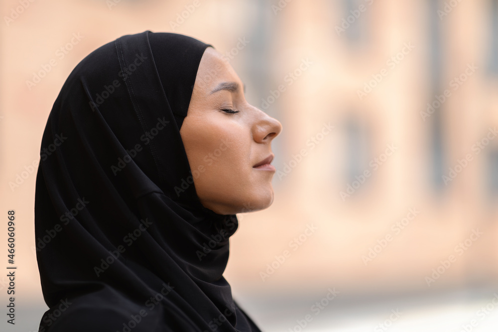 Outdoor Profile Portrait Of Calm Young Muslim Woman In Black Hijab Outdoor Profile Portrait Of Calm Young Muslim Woman In Black Hijab