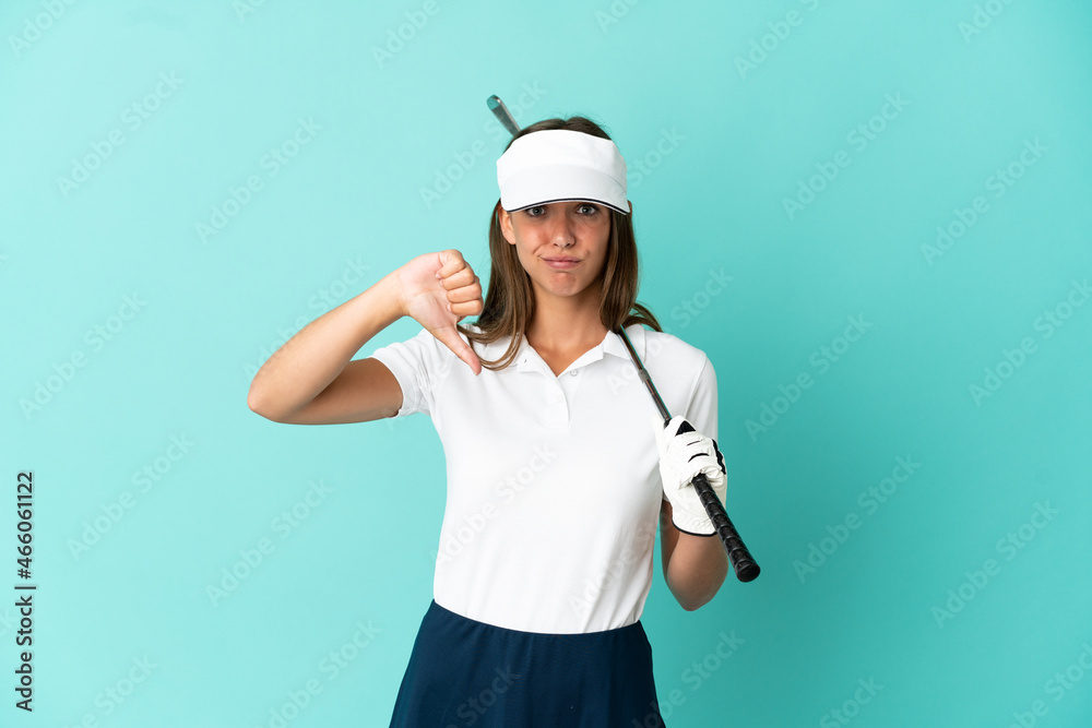 Woman playing golf over isolated blue background showing thumb down with negative expression