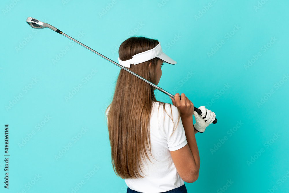 Young woman over isolated blue background playing golf Young woman over isolated blue background playing golf