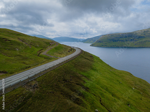 Fototapeta Naklejka Na Ścianę i Meble -  Beautiful view of the Faroe Islands roads - highways across the huge mountains and the ocean canals and small villages 