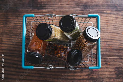 spices and seasonings in matching spice jars in ngrocery shopping basket, simple vegan ingredients and flavoring your dishes photo