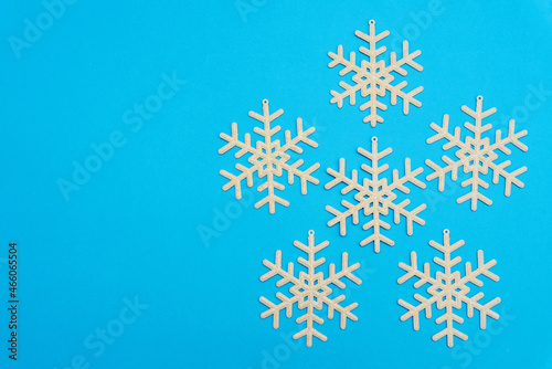 The Christmas composition, a group of white shiny snowflakes on a blue background form a large snowflake, copy space. Festive, New Year's concept. Minimum style. Top View