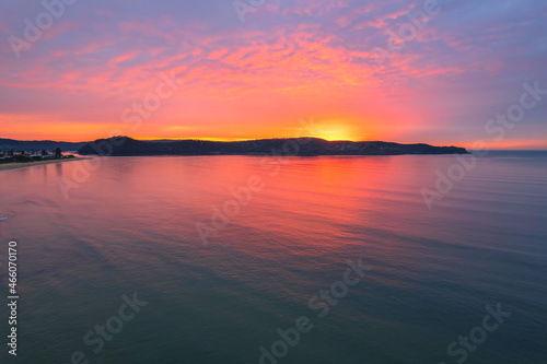 One hundred percent colourful cloud covered sunrise over the sea