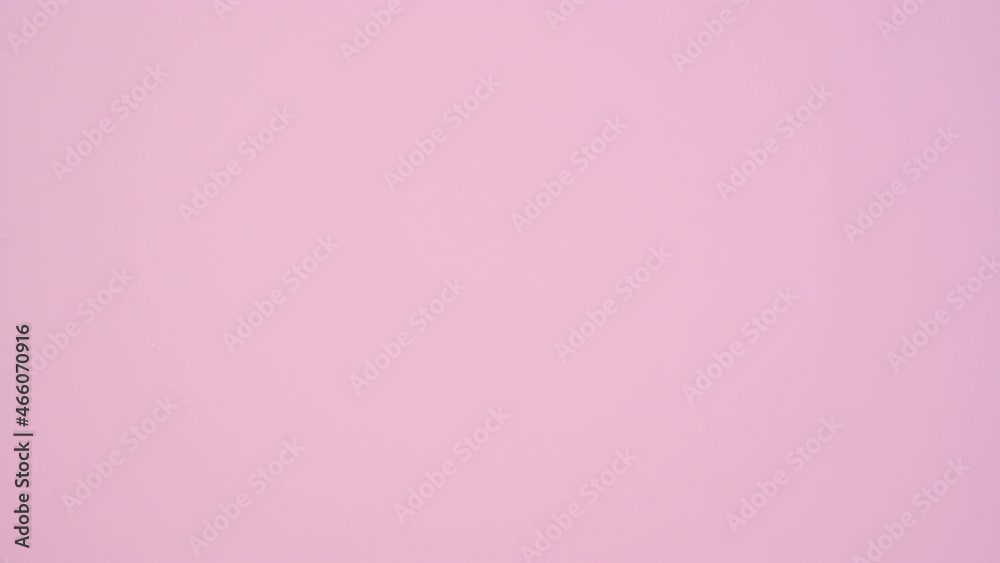 Silver gift with dark blue ribbon passing on right side of pastel pink theme. Stop motion
