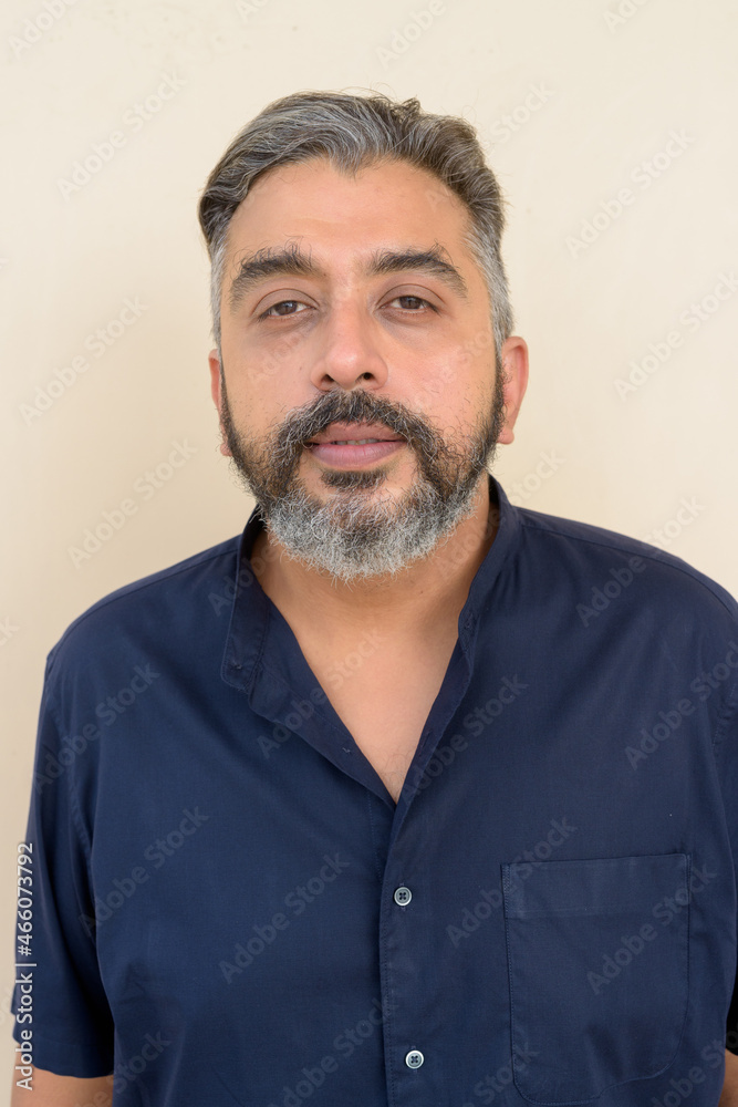Obraz premium Portrait of bearded Indian businessman against plain background