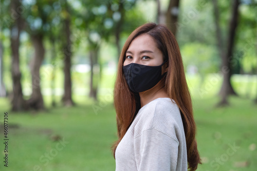 A young asian woman wearing protective face mask in the outdoors for Healthcare and Covid-19 concept