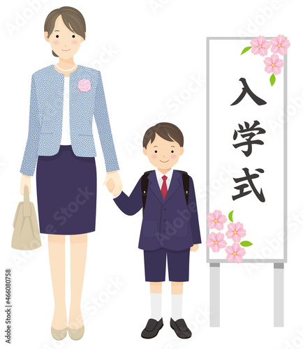 入学式の看板の横に手をつないで立つお母さんと男の子