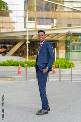 Full length portrait of successful young African businessman wearing suit and tie