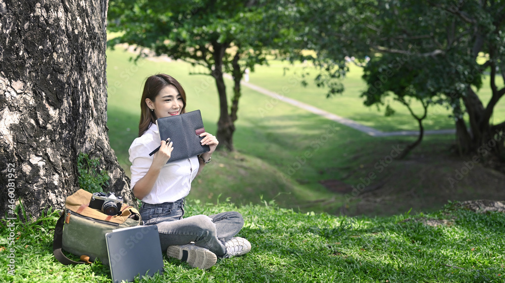 Pleased asian woman relaxing in public park. Pleased asian woman relaxing in public park.