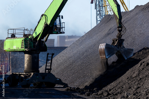 Industrial loading of coal into railway cars. Coal port of the city of Nakhodka. Large excavators are handling coal. photo