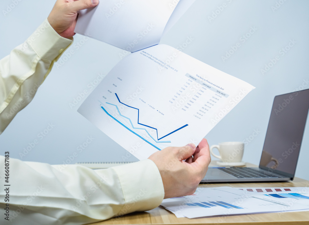 close up man work with business data graph on document above working desk close up man work with business data graph on document above working desk