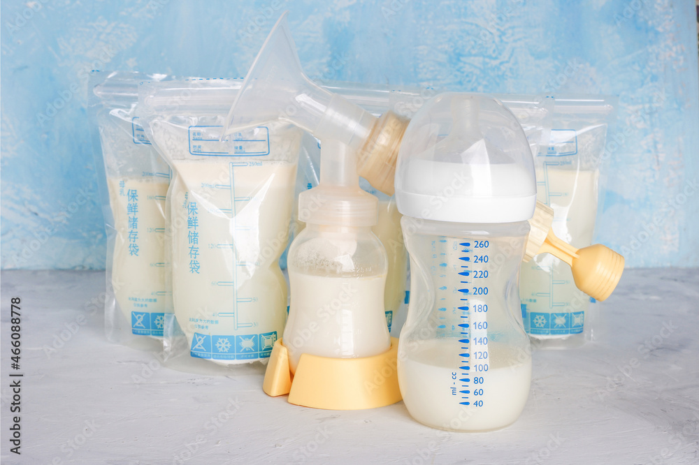 Bags with breast milk on blue background. Defrosting milk. Milk bottle