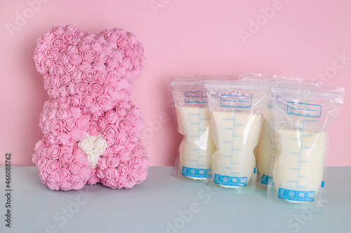 Bags with breast milk and bear toy of roses. Milk bank. Expressing breast milk. Breast-feeding. Freezing and storing milk. Donated milk.Copyspace