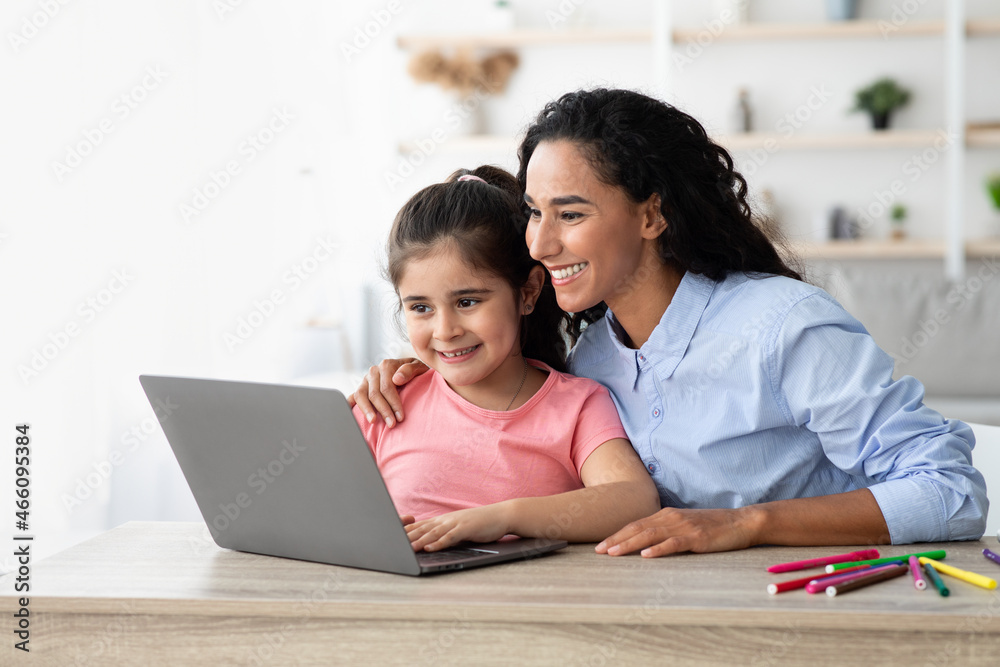 Online Education. Little Girl And Her Beautiful Mom Using Laptop At Home Online Education. Little Girl And Her Beautiful Mom Using Laptop At Home