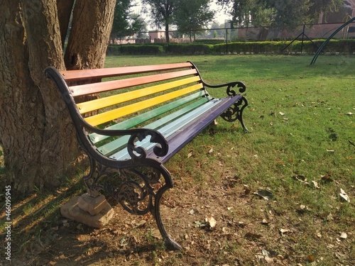 Metal rainbow color bench in a garden. 