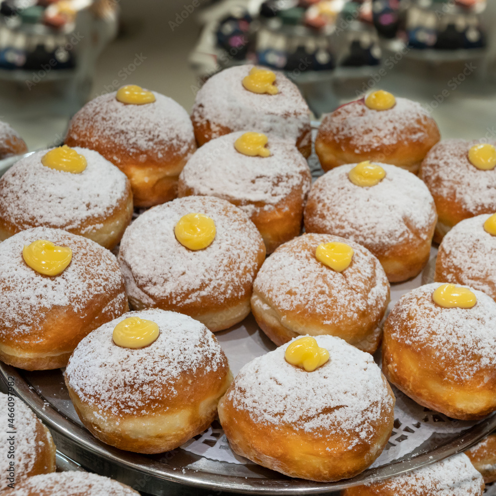 Fresh donuts at the bakery display for Hanukkah celebration. Selective focus.