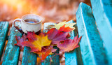 fili偶anka kawy w jesienny poranek, kawa o poranku i kolorowe jesienne li艣cie, herbata na tarasie 