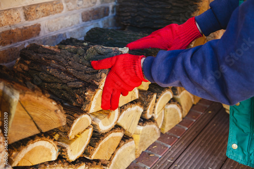 Gloved hands lay wooden log in niche photo