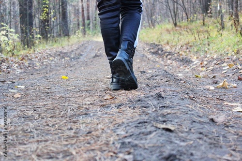 Walking or running with your feet on the trail  Hiking in the fall on the road in a secluded autumn forest with fallen yellow leaves. Green concepts. Travelers are walking. space for writing text on a