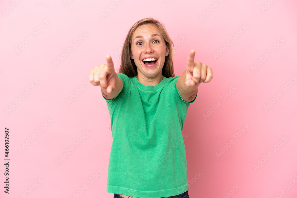 Young English woman isolated on pink background surprised and pointing front Young English woman isolated on pink background surprised and pointing front