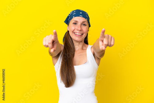 Young English woman isolated on yellow background surprised and pointing front