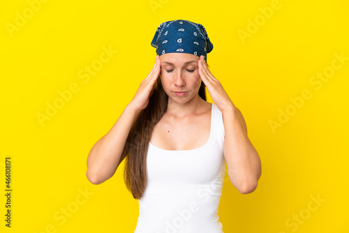 Young English woman isolated on yellow background with headache