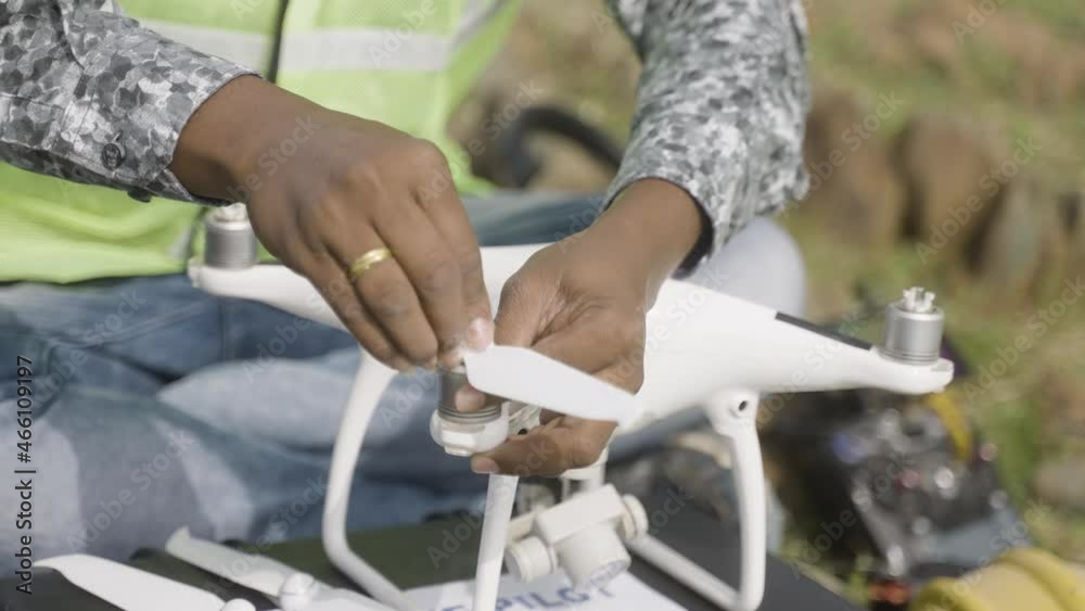 Close up of unrecognizable drone pilot adding propellers before flying - concept of professional UAV operator.