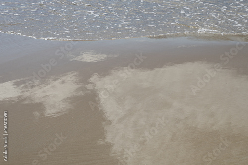reflection of couds in wet sand on the Mediterranean beach in Spain minimalist background