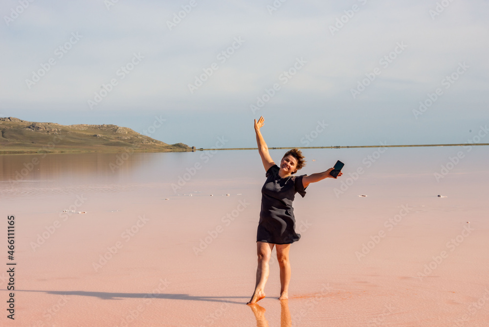 A middle-aged woman expresses delight on vacation in a salt lake.