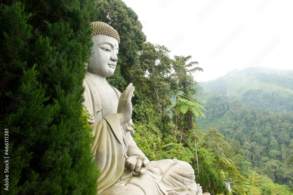 A attraktive buddha statue surrounded by tropical jungle at Genting Highlands, Malaysia A attraktive buddha statue surrounded by tropical jungle at Genting Highlands, Malaysia