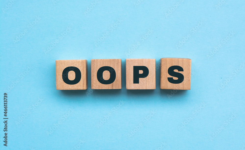 Word OOPS. Wooden small cubes with letters isolated on blue background with copy space available. Concept image. Word OOPS. Wooden small cubes with letters isolated on blue background with copy space available. Concept image.