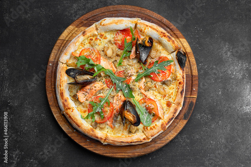 Pizza with seafood mussels shrimp salmon scallop on wooden board