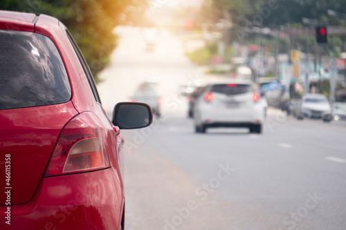 Rear side of red car on the asphalt road. With turn brake light. Blurred of cars and clear traffic on wide roads in Thailand.