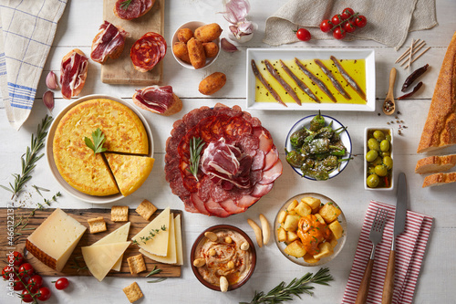 A wooden table with typical Spanish food seen from above
