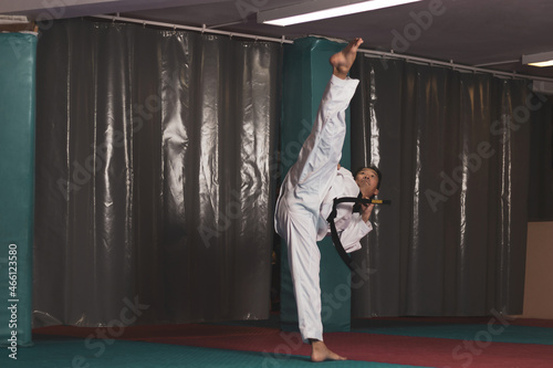 40-year-old Korean kicking taekwondo on a tatami mat. photo