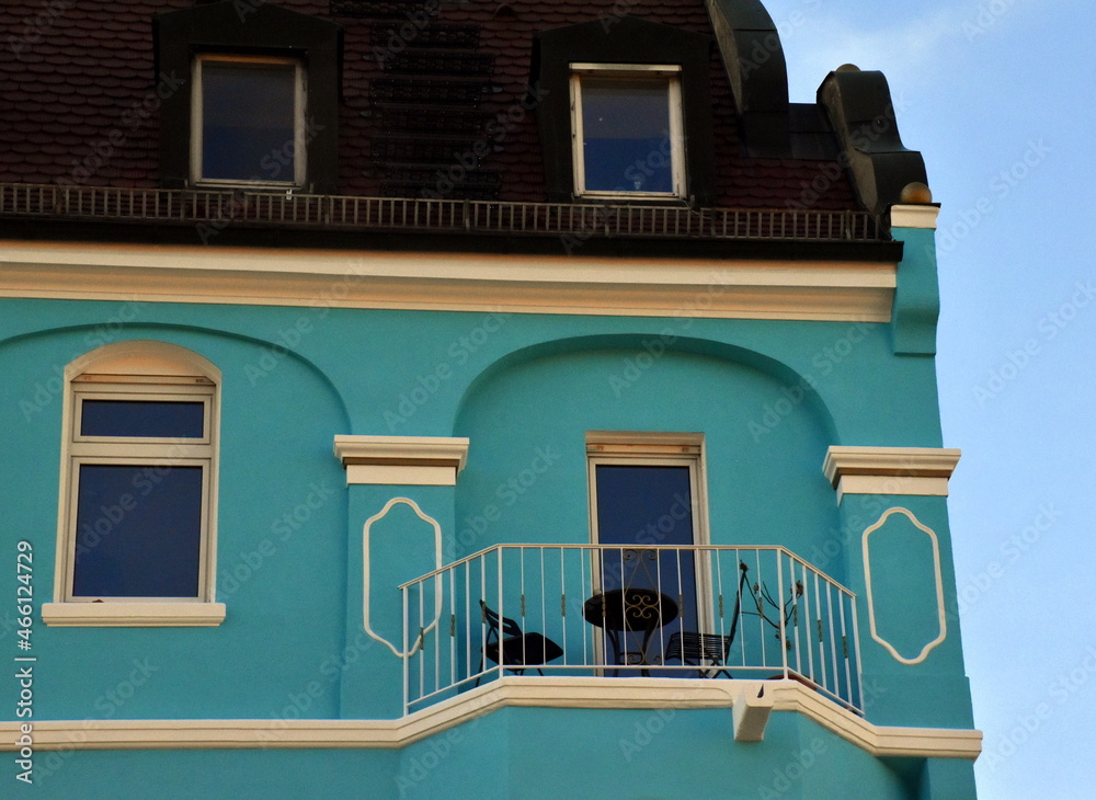Balkon an einer türkisen Altbaufassade