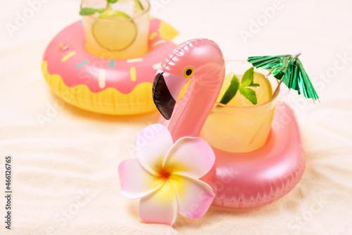 Inflatable Donut and Flamingo Toy Ring Holders for Swimming Pool Party with Glass of Cold Cocktail Tropical Monstera Horizontal Horizontal