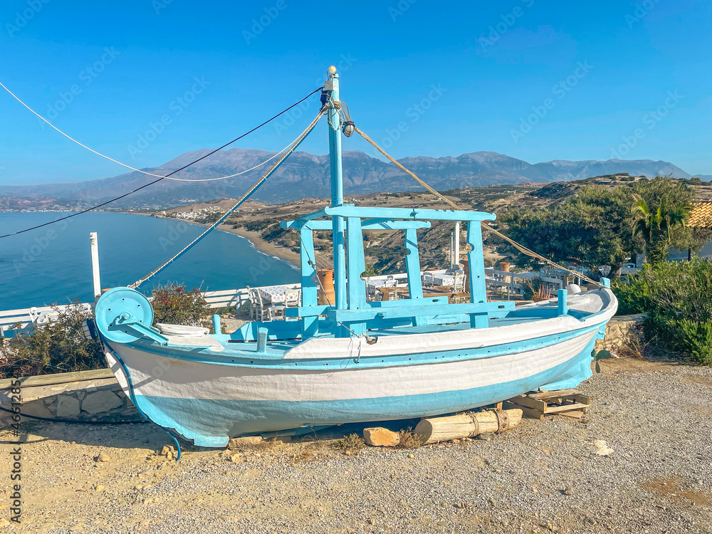 Typical greek trawler as decoration of a Taverna at the scenic outlook named Mystical View in Pitsidia on Crete. The viewpoint offers a fantastic look to the mediterranean and the Ida mountains Typical greek trawler as decoration of a Taverna at the scenic outlook named Mystical View in Pitsidia on Crete. The viewpoint offers a fantastic look to the mediterranean and the Ida mountains