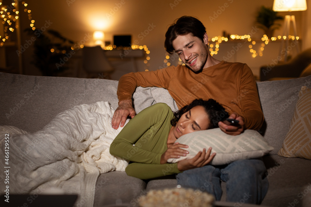 Boyfriend Looking At Sleeping Girlfriend Watching TV Indoors At Night