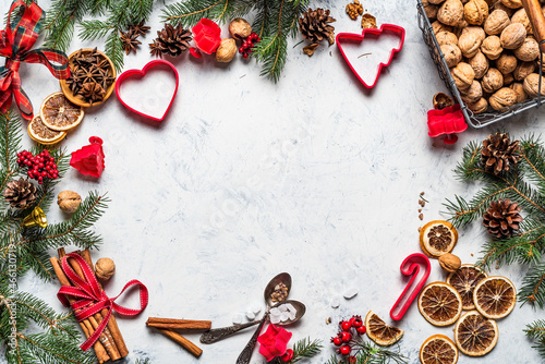 Christmas kitchen table background. Copy space. Christmas decorations  with fire tree, cinnamon walnuts, cookie cutters, sugar.